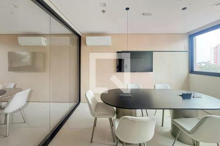 Sala de reuniões com mesa redonda e cadeiras brancas, TV na parede e janela com vista para a cidade. de apartamento para alugar com 1 quarto, 28m² em Ipiranga, São Paulo
