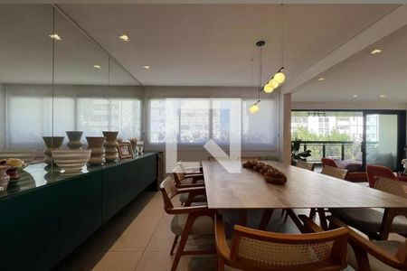 Sala com mesa de madeira e cadeiras de madeira e tecido, com iluminação de luzes de parede e janelas com cortinas de persiana. de apartamento à venda com 4 quartos, 265m² em Pinheiros, São Paulo