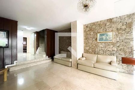 Sala de estar com sofás brancos e parede de pedra, iluminada por uma lâmpada de cristal. de apartamento à venda com 4 quartos, 105m² em Cerqueira César, São Paulo