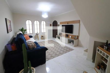 Sala com sofá azul, mesa de centro e TV em uma casa com estilo moderno e arquitetura simples. de casa à venda com 3 quartos, 161m² em Jardim D’abril, Osasco