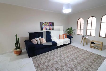 Sala com sofá azul e cama de solteiro, com pintura de leão na parede e janelas arqueadas. de casa à venda com 3 quartos, 161m² em Jardim D’abril, Osasco