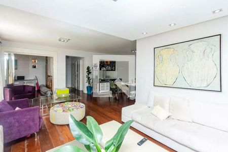 Sala com móveis modernos e pintura branca, com uma planta no centro e uma pintura de vasos na parede. de apartamento à venda com 4 quartos, 195m² em Jardim Paulista, São Paulo