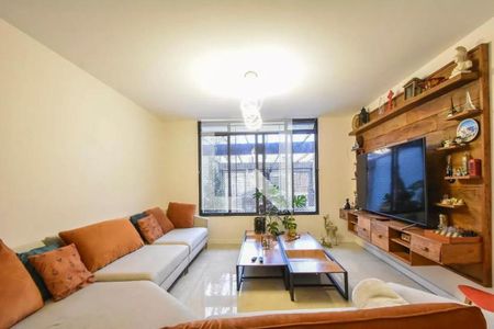Sala com sofás brancos e laranja, TV e mesa de centro, com janela grande e iluminação boa. de casa à venda com 4 quartos, 120m² em Vila Cordeiro, São Paulo