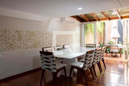 Sala de jantar com mesa branca e cadeiras de madeira e tecido, com vista para a varanda e jardim. de casa à venda com 6 quartos, 280m² em Cerqueira César, São Paulo