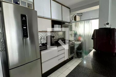 Cozinha com geladeira, fogão, microondas e pia, com móveis brancos e azulejos brancos e pretos. de apartamento à venda com 2 quartos, 64m² em Vila Piratininga, São Paulo