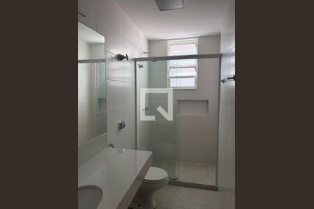 Banheiro com piso de porcelanato, pia e vaso sanitário brancos, e janela pequena. de apartamento para alugar com 3 quartos, 100m² em Gávea, Rio de Janeiro