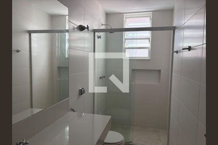 Banheiro com piso de porcelanato, pia e vaso sanitário brancos, e janela pequena. de apartamento para alugar com 3 quartos, 100m² em Gávea, Rio de Janeiro