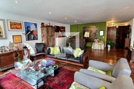 Sala de estar com móveis de madeira e pinturas na parede. de apartamento à venda com 6 quartos, 370m² em Cerqueira César, São Paulo