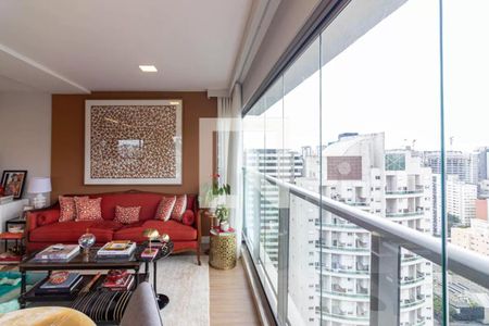Sala de estar com vista para a cidade, com móveis em tons de vermelho e dourado. de apartamento à venda com 6 quartos, 170m² em Indianópolis, São Paulo