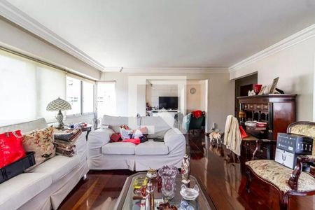 Sala com sofás brancos, móveis de madeira e decoração em tons de vermelho e branco. de apartamento à venda com 6 quartos, 260m² em Cerqueira César, São Paulo