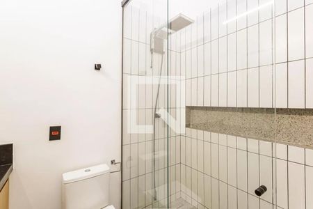 Banheiro com chuveiro e pia branca, paredes de azulejos brancos e piso de azulejos brancos. de casa à venda com 2 quartos, 100m² em Moema, São Paulo
