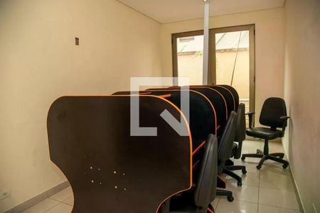 Sala de jogos com mesas de computador e cadeiras, iluminada por luzes brilhantes. de apartamento à venda com 1 quarto, 30m² em Brooklin Novo, São Paulo