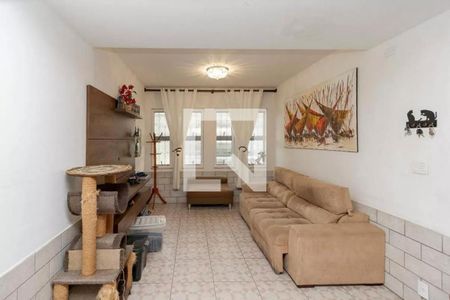 Sala com sofá, quadro de arte e móveis de madeira, com iluminação natural e boa qualidade de iluminação artificial. de casa à venda com 4 quartos, 220m² em Brooklin, São Paulo