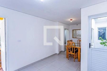 Comedor com mesa e cadeiras de madeira, iluminado por lâmpadas e com uma porta de vidro. de casa à venda com 3 quartos, 170m² em Vila Cavaton, São Paulo