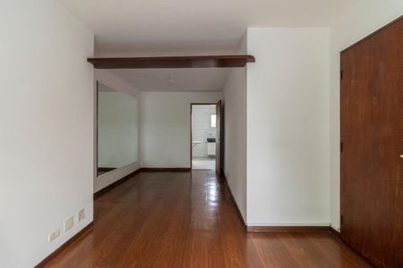 Espaço de entrada com piso de madeira e porta de madeira, com uma grande espelho na parede e uma luz natural que entra pela porta. de apartamento à venda com 2 quartos, 65m² em Vila Congonhas, São Paulo