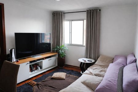 Sala de estar com sofá, TV e mesa de centro, iluminada por janelas grandes e com piso de madeira. de apartamento à venda com 3 quartos, 78m² em Vila Alpina, São Paulo