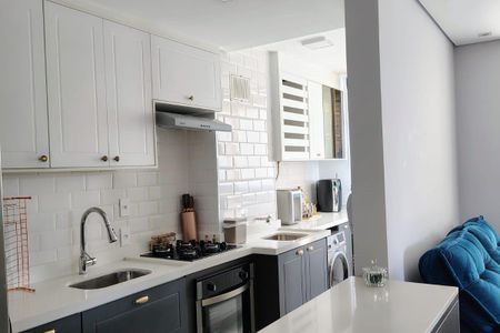 Apartamento à venda com 93m², 3 quartos e 2 vagasCozinha com móveis brancos e pretos, com um fogão e uma geladeira, com um piso de porcelanato e uma bancada de granito.
