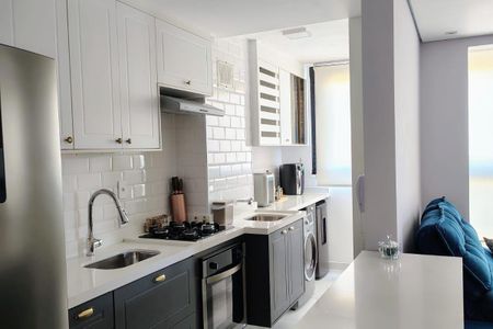 Apartamento à venda com 93m², 3 quartos e 2 vagasCozinha moderna com móveis brancos e pretos, iluminada por luz natural e artificial, com um ambiente limpo e organizado.