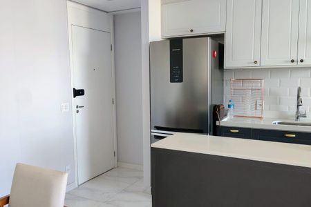 Apartamento à venda com 93m², 3 quartos e 2 vagasCozinha com geladeira, pia e armários brancos, com um pequeno espaço de trabalho e uma cadeira.