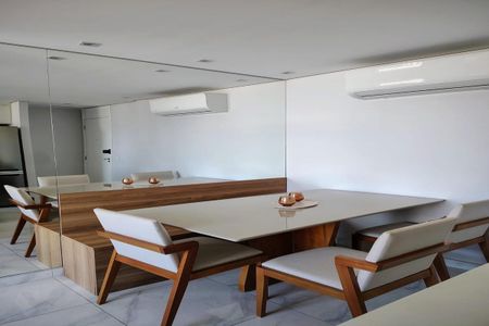 Apartamento à venda com 93m², 3 quartos e 2 vagasSala de jantar com mesa de madeira e cadeiras brancas, iluminada por lâmpadas de LED, com um ar condicionado instalado na parede acima da mesa.