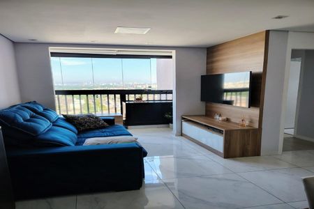 Apartamento à venda com 93m², 3 quartos e 2 vagasSala com sofá azul e TV na parede, com vista para a cidade.