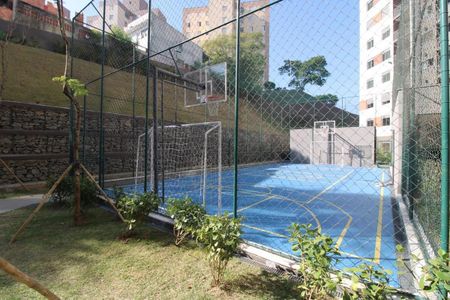 Apartamento à venda com 47m², 2 quartos e 1 vagaQuadra de futsal com gramado e canteiro de grama ao redor, cercada por muro de pedra e arame farpado.