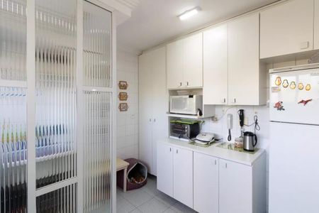 Apartamento à venda com 77m², 3 quartos e 1 vagaCozinha com geladeira, fogão e micro-ondas, com iluminação adequada e mobiliário simples.