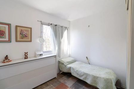 Apartamento à venda com 77m², 3 quartos e 1 vagaQuarto com cama simples, janela e prateleira com objetos decorativos.