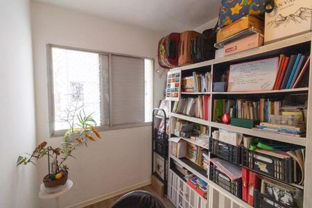 Apartamento à venda com 77m², 3 quartos e 1 vagaQuarto com móveis e livros, janela e planta, parede branca e teto branco.