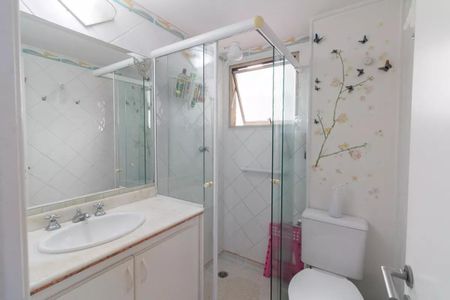 Apartamento à venda com 77m², 3 quartos e 1 vagaBanheiro com piso de porcelanato, pia e vaso sanitário brancos, e uma janela pequena.