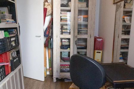 Cabinete de madeira com prateleiras e porta de vidro, com mesa e cadeira em frente, ambiente organizado e bem iluminado. de apartamento à venda com 3 quartos, 77m² em Jardim das Vertentes, São Paulo