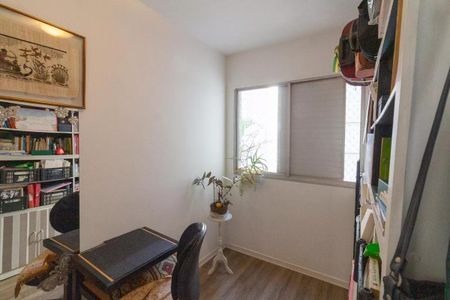 Apartamento à venda com 77m², 3 quartos e 1 vagaEscritório com mesa e cadeira, prateleiras com livros e objetos, janela com persianas e plantas.