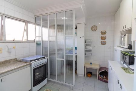 Apartamento à venda com 77m², 3 quartos e 1 vagaCozinha com móveis brancos e azuis, iluminada por luz natural e artificial, com um fogão e geladeira, e uma janela grande.