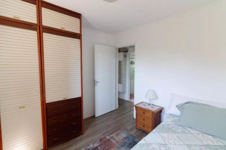Apartamento à venda com 77m², 3 quartos e 1 vagaQuarto com cama, armário e porta de entrada.