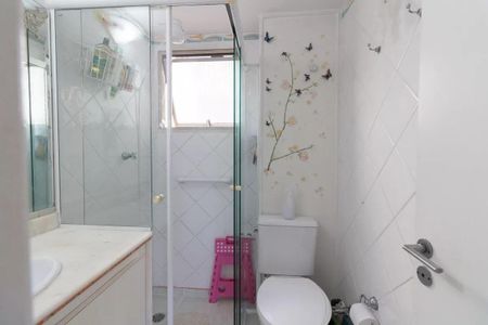 Apartamento à venda com 77m², 3 quartos e 1 vagaBanheiro com ducha, vaso sanitário e pia, com decoração de borboletas e flores na parede.