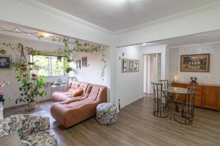 Sala com móveis de cores pastéis, plantas e decoração simples, com uma janela grande e iluminação natural. de apartamento à venda com 3 quartos, 77m² em Jardim das Vertentes, São Paulo