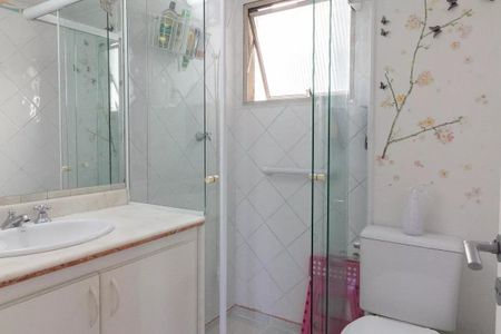 Apartamento à venda com 77m², 3 quartos e 1 vagaBanheiro com piso de porcelanato, pia e vaso sanitário brancos, e parede com decoração floral.