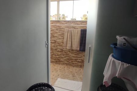 Casa à venda com 131m², 2 quartos e 1 vagaBanheiro com piso de porcelanato, paredes de azulejos e toalhas penduradas, com vista para a rua.