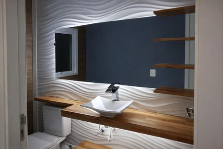 Casa à venda com 131m², 2 quartos e 1 vagaBanheiro com piso de porcelanato, pia de cerâmica e espelho grande, com iluminação adequada e acabamento de madeira.