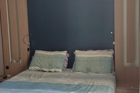 Cama simples com duas almofadas e lençóis azuis e brancos, com uma parede azul escuro no fundo. de casa à venda com 2 quartos, 131m² em Chácara do Solar II (Fazendinha), Santana de Parnaíba