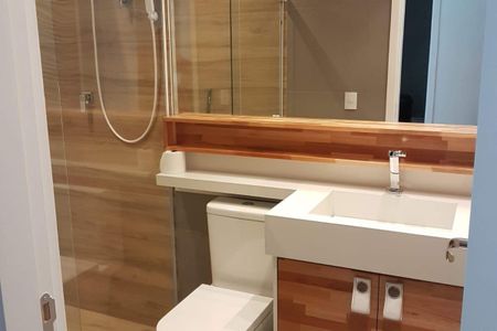 Casa à venda com 131m², 2 quartos e 1 vagaBanheiro com piso de porcelanato, pia e vaso sanitário brancos, e espelho acima do pia.