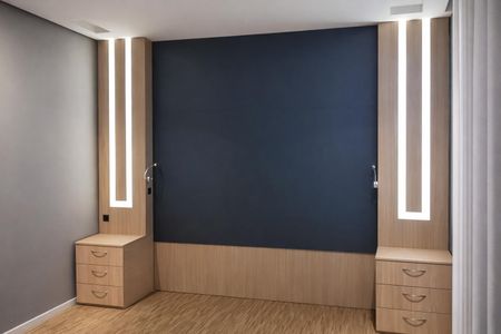 Cuarto com duas mesas de cabeceira e duas luminárias de parede, com um piso de madeira e paredes de azul e madeira. de casa à venda com 2 quartos, 131m² em Chácara do Solar II (Fazendinha), Santana de Parnaíba