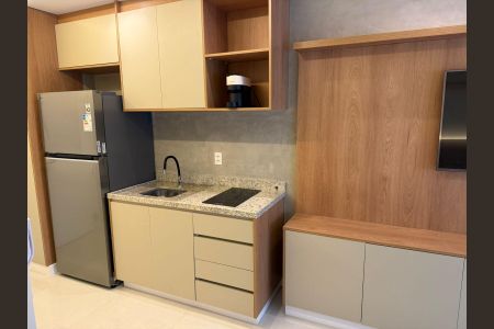 Studio à venda com 25m², 1 quarto e sem vagaCozinha com geladeira e fogão, com móveis de madeira e piso de porcelanato.