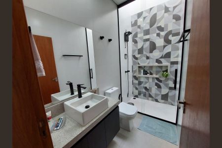 Banheiro com piso de porcelanato, pia e vaso sanitário brancos, e espelho grande. de casa à venda com 3 quartos, 155m² em Medeiros, Jundiaí