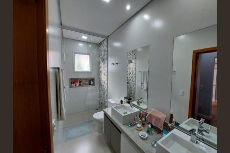 Banheiro com piso de porcelanato, pia e vaso sanitário brancos, e espelho grande. de casa à venda com 3 quartos, 155m² em Medeiros, Jundiaí