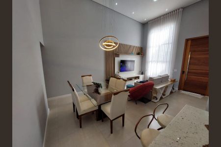 Sala com mesa de vidro, sofá e TV, iluminada por lâmpadas circulares. de casa à venda com 3 quartos, 155m² em Medeiros, Jundiaí