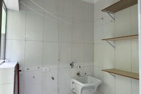Banheiro com pia e vaso sanitário brancos, paredes de azulejos brancos, prateleiras de madeira e janela com persianas de alumínio. de apartamento à venda com 3 quartos, 112m² em Vila Eldizia, Santo André