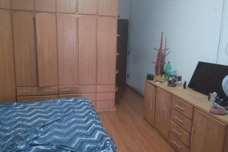 Quarto com móveis de madeira e cama com cobertor azul e branco. de casa à venda com 3 quartos, 130m² em Bela Vista, Osasco