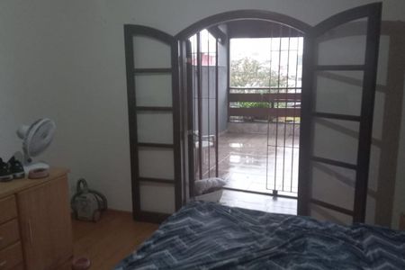 Quarto com porta de vidro para varanda e cama com cobertor azul e branco. de casa à venda com 3 quartos, 130m² em Bela Vista, Osasco
