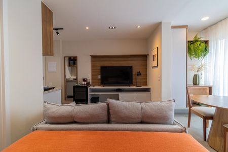 Apartamento à venda com 28m², 1 quarto e sem vagaSala com sofá, TV e mesa de jantar, com iluminação natural e decoração simples.